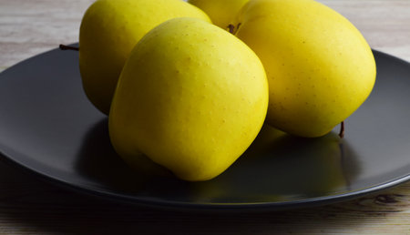 Close up, yellow apples on dark plate.の写真素材