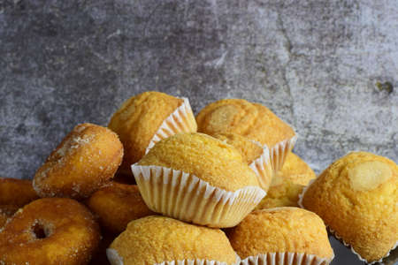 Dish with stacked cupcakes and sugar donuts, stone bottom.の写真素材