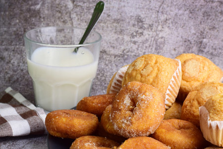 Close up, sugar donuts, muffins on plate, interior, stone background.
