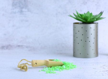 Wooden spoon with aloe vera bath salts, for relaxing moments. Light-colored stone background and...