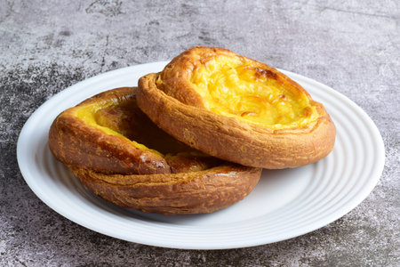Sweet. White porcelain plate with two ensaimadas covered with burnt cream, typical of Spain.