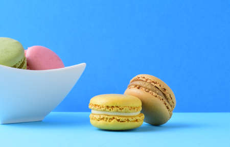 Colored macarons, isolated on blue background, typical french sweet.の写真素材