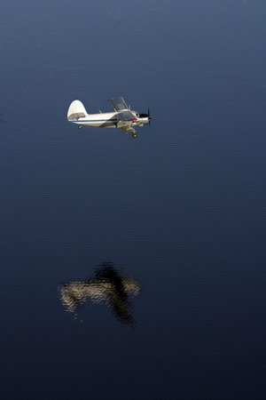 The Aeroplane flies over lake (sea). The View on height of the flight of the bird.