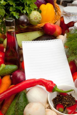 This is a notebook of paper on a background of fresh vegetables. This recipe is delicious and healthy dishes.の写真素材