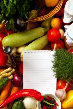 This is a notebook of paper on a background of fresh vegetables. This recipe is delicious and healthy dishes.の写真素材