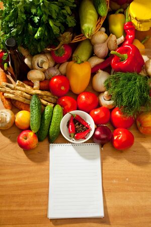 This is a notebook of paper on a background of fresh vegetables. This recipe is delicious and healthy dishes.の写真素材
