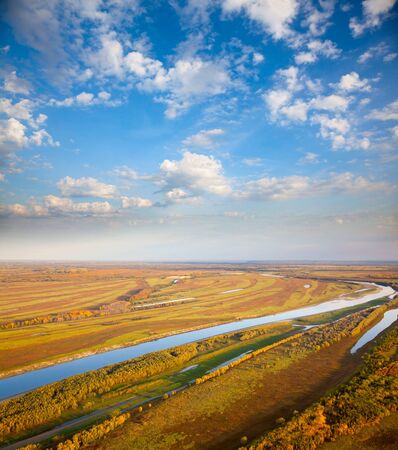 Aerial view of the floodplain of river under clouds during the autumn の写真素材