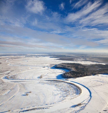 Aerial view of forest of plain and small river during a winter day.の写真素材