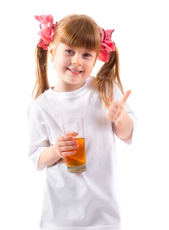 Little girl having a glass of refreshing orange juice which derived from orangeの写真素材