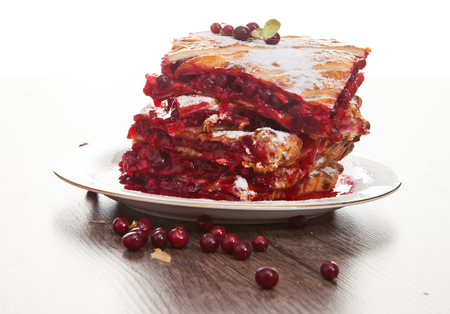 Cranberry Pie for Christmas and tasty tea with foxberry leafs are on wooden table.の写真素材