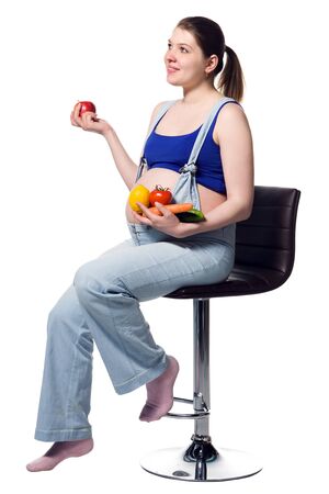 Beautiful pregnant woman in blue with fresh fruits and vegetables, healthy life concept, isolated over a white backgroundの写真素材