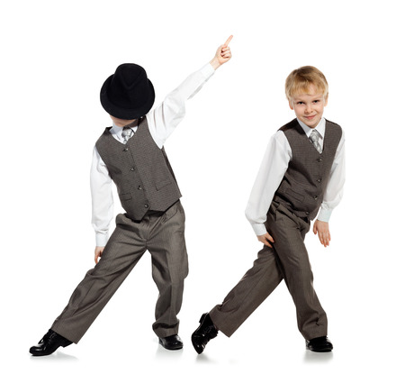 Little boy in suit and hat is dansing, isolated on white. Little boy, who is looked as businessman, is dancing on white background.の写真素材