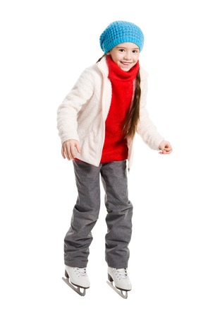 Pretty cheerful little girl doing her first steps in skates on rink, isolated on whiteの写真素材