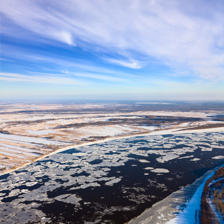 Aerial view of the great river with floating ice floes during the spring day. Drifting of ice. Driving of ice. Ice floe.の写真素材