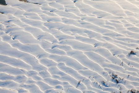 Sandy dunes covered snow on the river bankの写真素材