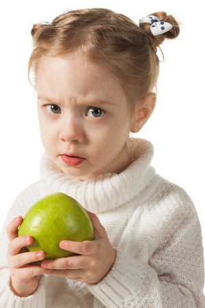 Unhappy girl with green appleの写真素材