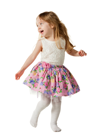 Cute three-year girl jumping with joy isolated on white backgroundの写真素材