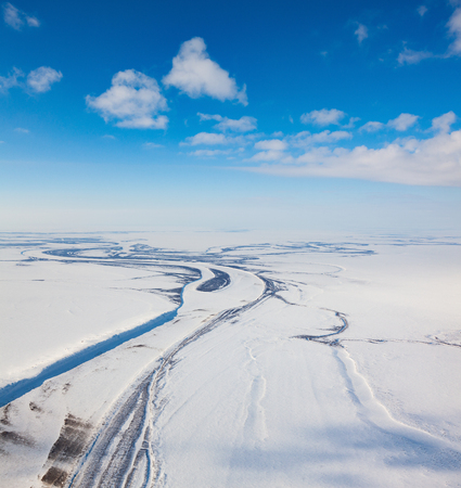 Aerial view above the river in endless tundra in winter time.の写真素材