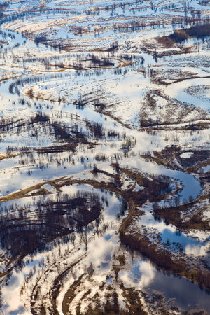 Aerial view of forest river during spring floodingの写真素材