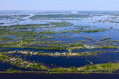 Flooded houses in the floodplain of a large river during the spring flood, bird's eye viewの写真素材