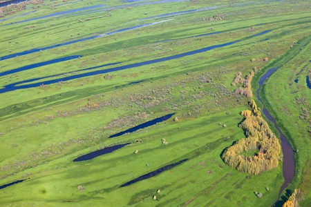 Aerial view of marshy terrain beside river in autumn.の写真素材