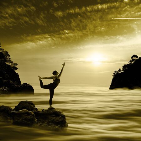Woman Doing Yoga Exercises At Sunrise Backgroundの写真素材
