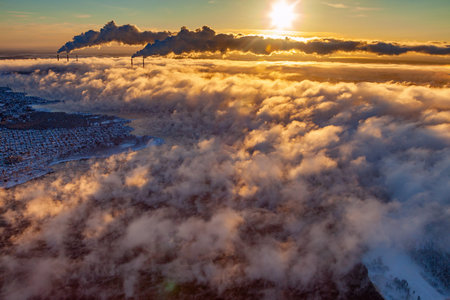 Power station with rising steam from pond to sky in winter season, aerial view.