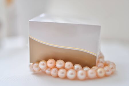 Beautiful packaging for cosmetics. Box for cosmetics in a collage with pearlsの写真素材