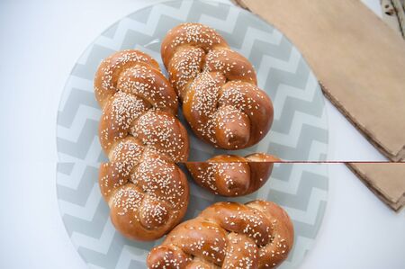 Challah or Hala is a traditional jewish sweet fresh sabbath bread loaf, fresh bun on cutting board. Brioche bread on breakfast. Easter, homemadeの写真素材