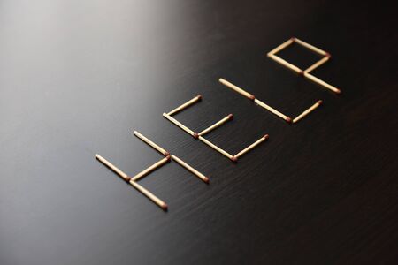 Help word from matches. Word help from matches on black wood. Concept of matches, the inscription Help.の写真素材