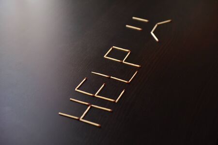 Help word with sad smile from matches. Word help with sad smile from matches on black wood. Concept of matches, the inscription Help with a sad smile.の写真素材
