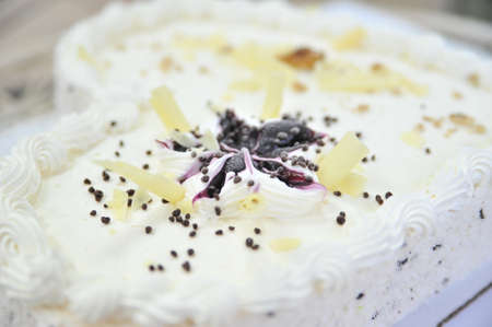 White frosted cake on the sides with hand crafted with hand crafted chocolates frosting decorations on tops.の写真素材