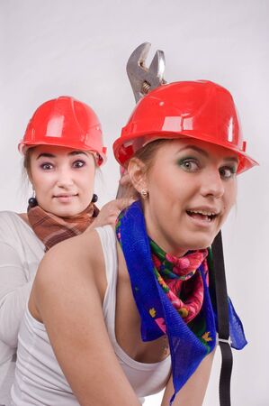 Two girls having fun in construction helmetsの写真素材