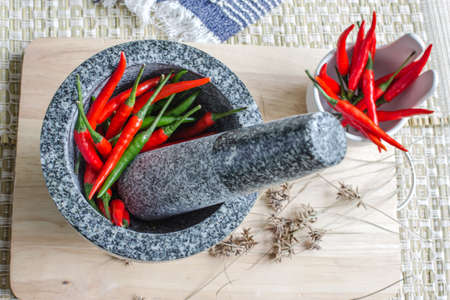 Red and green pepper in mortarの写真素材