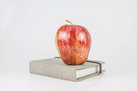 book and apple on a white background の写真素材
