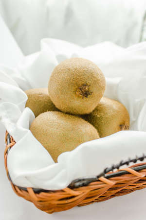 Kiwi fruits on the Empty yellow wicker trayの写真素材