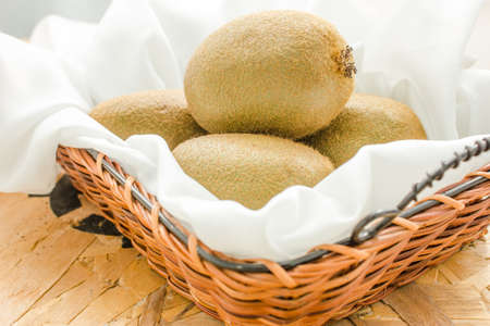 Kiwi fruits on the Empty yellow wicker trayの写真素材