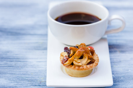 Black coffee and Fruit Tart  on wooden table