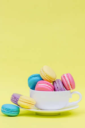 Sweet and colourful french macaroons in cup on retro-vintage backgroundの写真素材