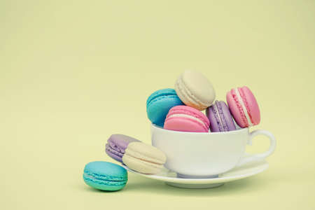 Sweet and colourful french macaroons in cup on retro-vintage backgroundの写真素材