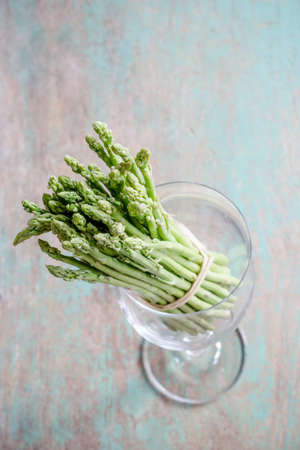 Asparagus in wine glass on wooden tableの写真素材