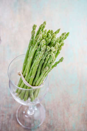 Asparagus in wine glass on wooden tableの写真素材