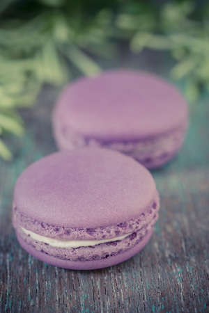 Lavender macaroons with cream on a wooden table の写真素材