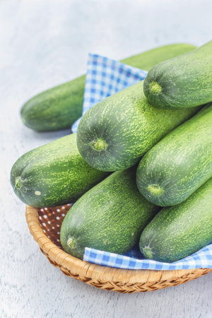 fresh cucumbers in basket on a wooden backgroundの写真素材
