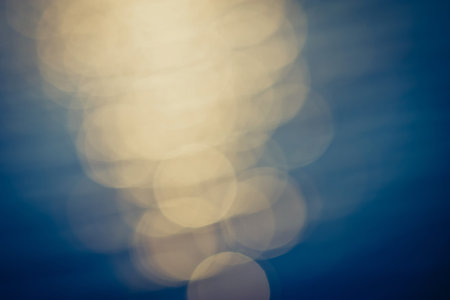 Golden sunlights on blue water background 