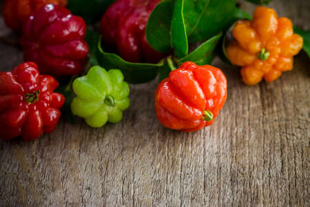 Tropical fruit also called Pitanga, Brazilian Cherry, Suriname Cherry, Cayenne Cherry on wooden background.の写真素材