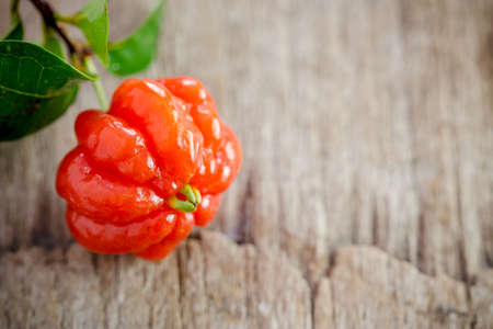 Tropical fruit also called Pitanga, Brazilian Cherry, Suriname Cherry, Cayenne Cherry on wooden background.の写真素材