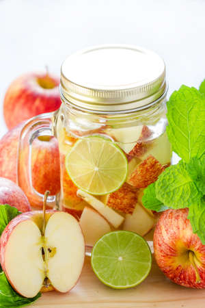 Mug delicious refreshing drink of apple fruits with mint on wooden, Infused waterの写真素材