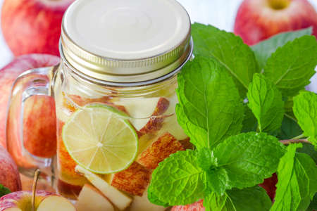 Mug delicious refreshing drink of apple fruits with mint on wooden, Infused waterの写真素材