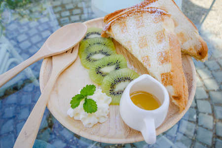 Kiwi waffle with honey  on wooden plateの写真素材